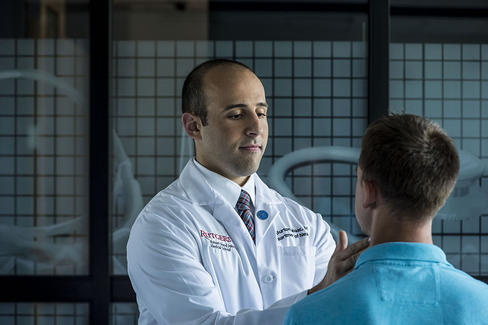 AUC alumnus Burton Tabaac, MD, examines a patient