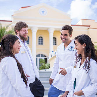 Students in white coats in front of school