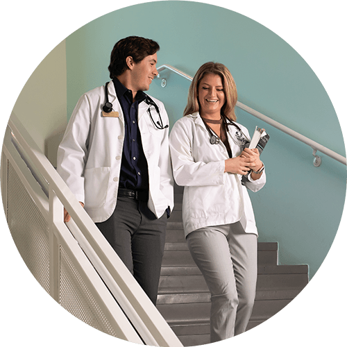 Two doctors walking down stairs in white coats