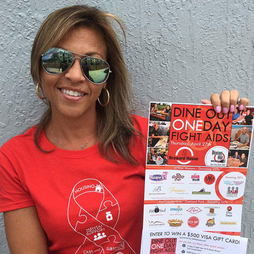 Woman holding Dine Out One Day Fight Aids flyer