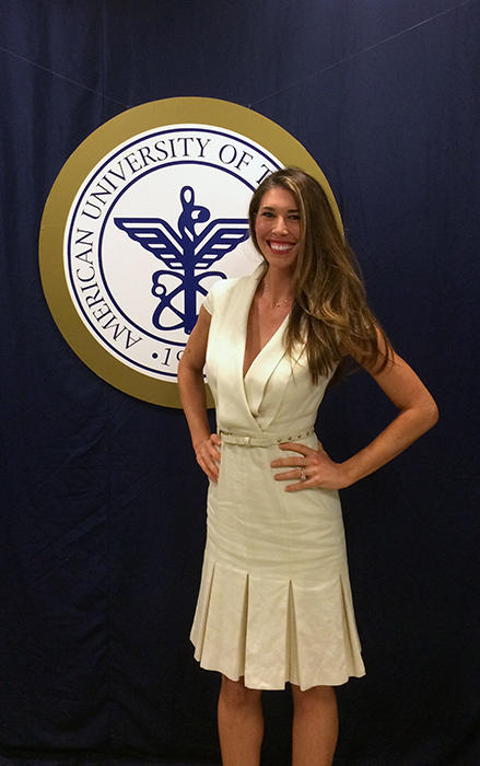 Heather Christopherson standing next to AUC seal