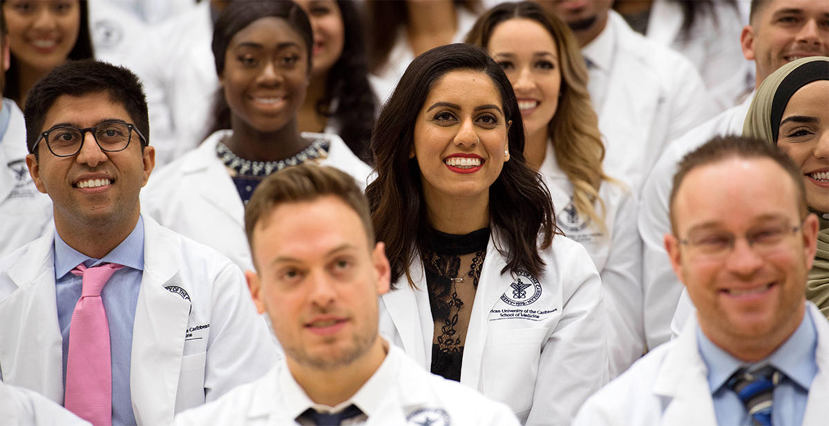 Students smiling in white coats